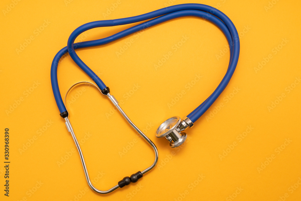 Stethoscope on yellow background, top view. Medical instrument Stethoscope on yellow background, top view. Medical instrument