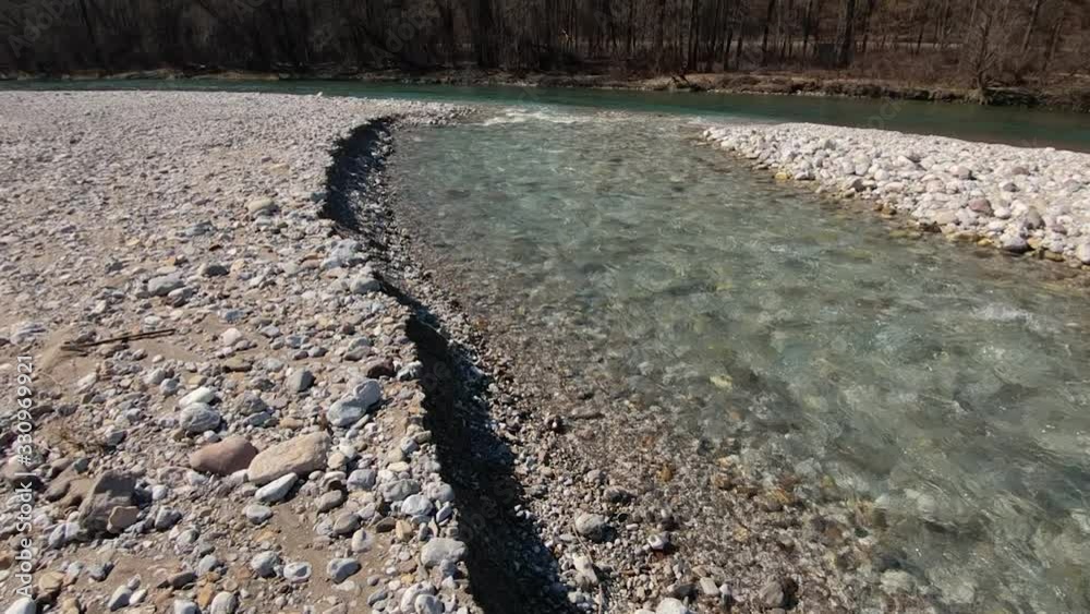 Shallow Alpine stream joins with wider river in amazing nature. Confluence of two rivers. Erosion of pebble material of latest floods. Wide shoot, tilt down Shallow Alpine stream joins with wider river in amazing nature. Confluence of two rivers. Erosion of pebble material of latest floods. Wide shoot, tilt down