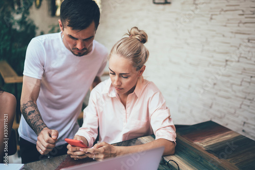 Couple using smartphone and working together