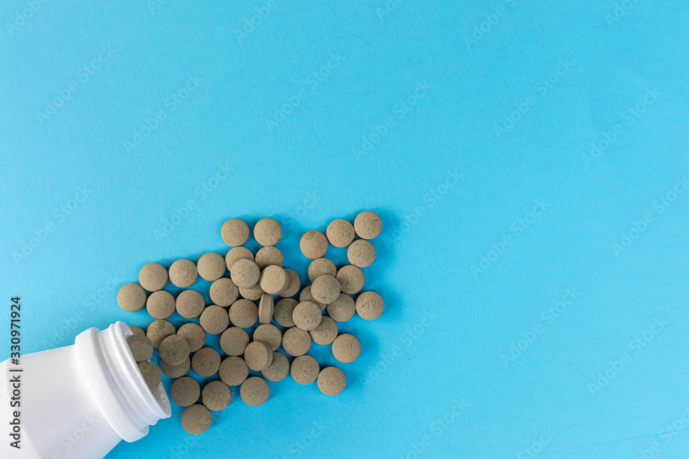 Medicine herbal pills with white bottle on blue background. Medicine herbal pills with white bottle on blue background.