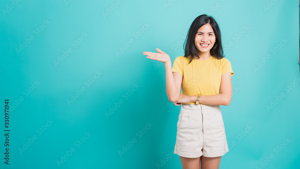 Young woman standing showing hand presenting product Young woman standing showing hand presenting product