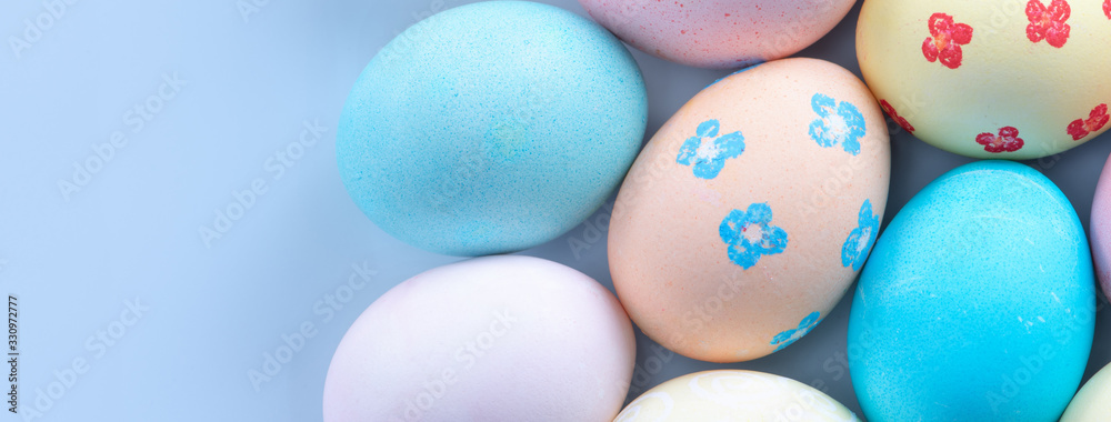 Colorful Easter hunting eggs dyed by colored water with beautiful pattern on pastel blue background, design concept of holiday, top view, copy space.