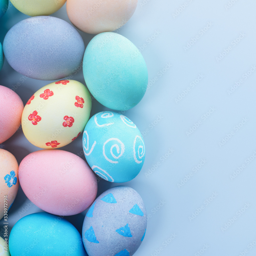 Colorful Easter hunting eggs dyed by colored water with beautiful pattern on pastel blue background, design concept of holiday, top view, copy space.