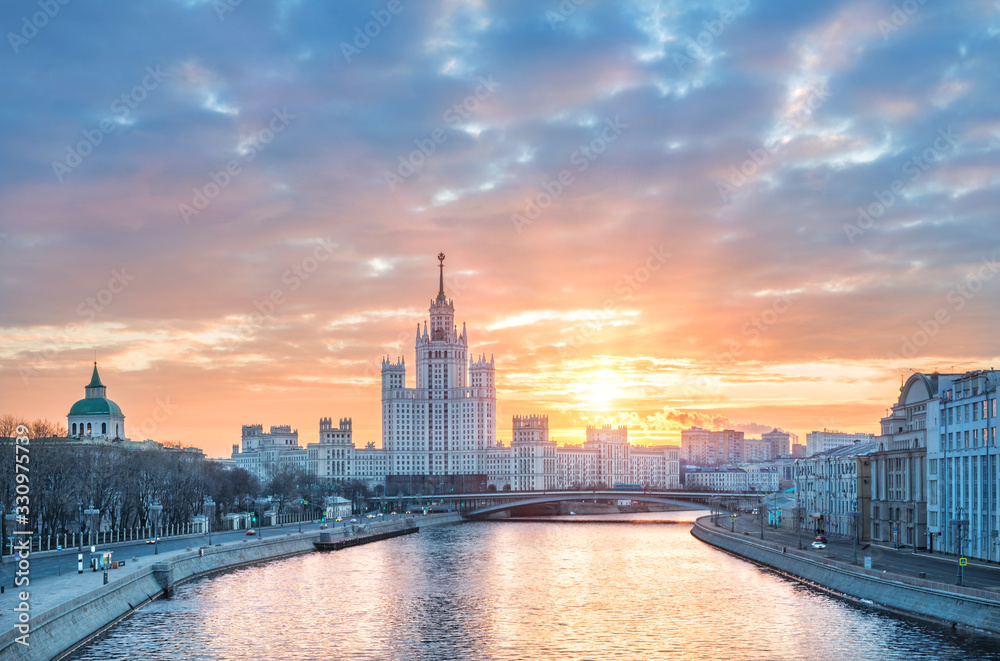 Naklejka premium Pomarańczowe niebo o świcie nad wieżowcem