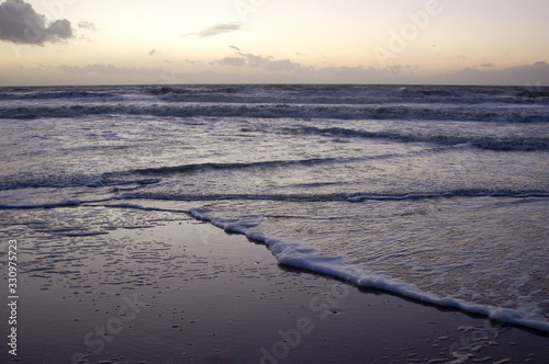 Vagues sur une plage au coucher du soleil photo