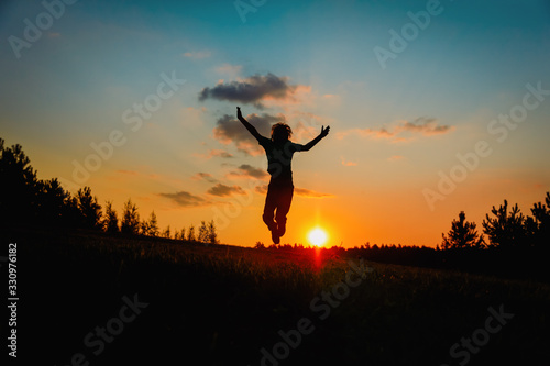 happy boy jumping at sunset sky, kid enjoy nature