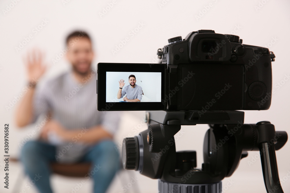 Young blogger recording video indoors, focus on camera screen - obrazy, fototapety, plakaty 