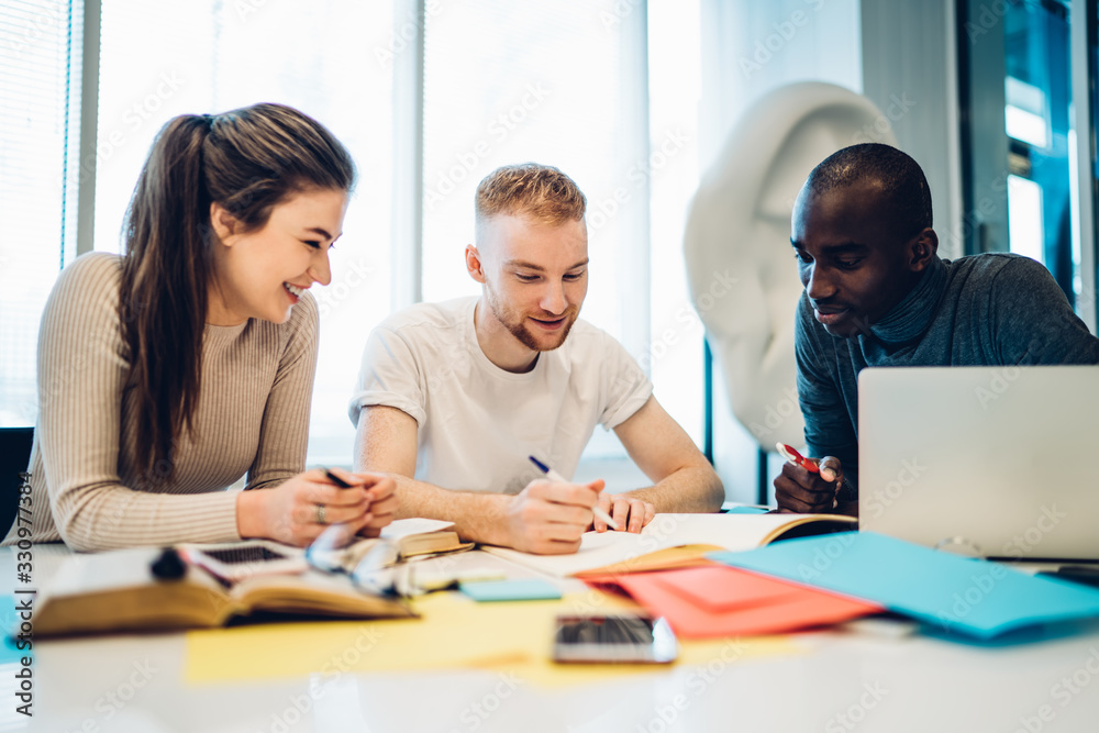 Joyful multiethnic colleagues working together at table Joyful multiethnic colleagues working together at table