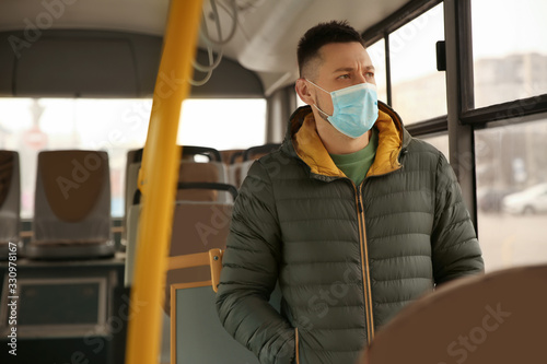 Man with disposable mask on bus. Virus protection