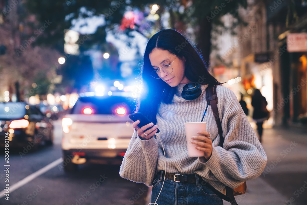 Fototapeta premium Woman with drink and phone on street