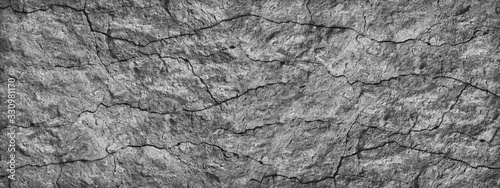 Cracked stone surface. Close-up. Gray abstract grunge background. Banner with gray rock texture. Copy space.