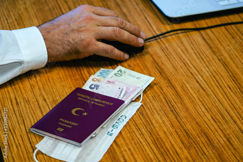 Turkish pasaport and Turkish Lira and a green surgical face mask. Concept about COVID-19 transmits via money.  photo