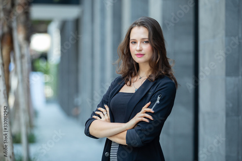 Portrait beautiful business woman in black suit success perfect standing front office, looking at camera.