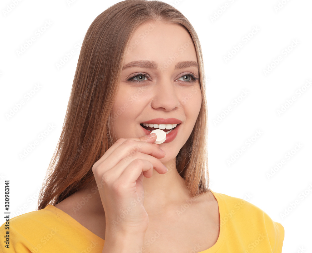 Young woman taking vitamin pill on white background Young woman taking vitamin pill on white background