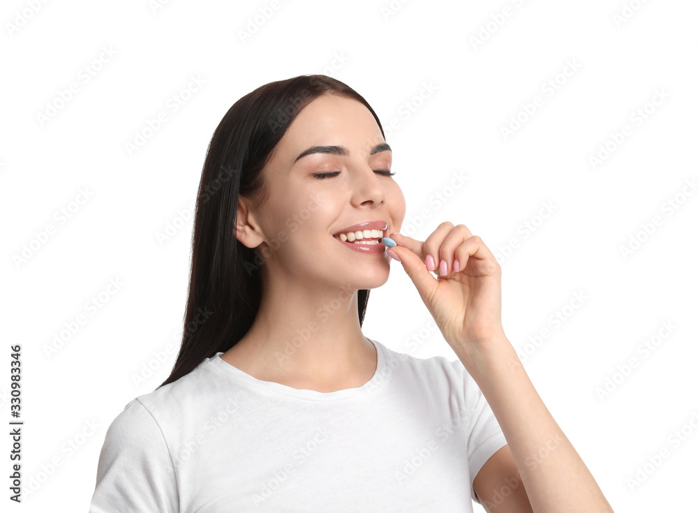 Young woman taking vitamin pill on white background Young woman taking vitamin pill on white background