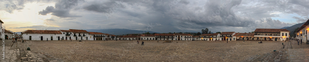 Der riesige Marktplatz der Stadt Villa de Leyva in Kolumbien unter einem wolkenverhangenen dramatischen Himmel als Panorama