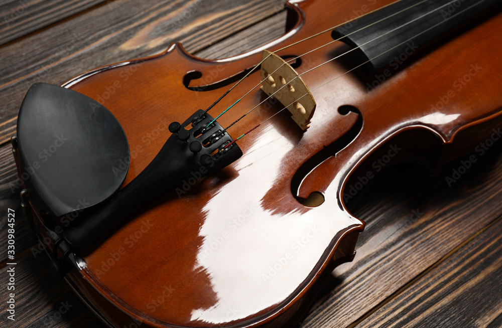 Fototapeta premium Classic violin on wooden background, closeup view