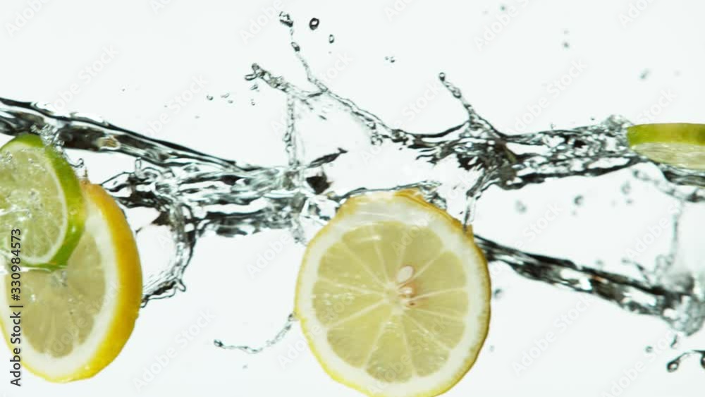 Super slow motion of lime and lemon slices with water splash on white background. Filmed on high speed cinema camera, 1000 fps.