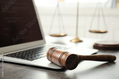 Laptop, gavel and scales on table, closeup. Cyber crime