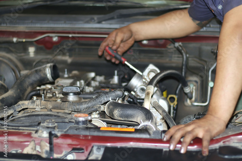 Image of a mechanic checking and fixing the engine