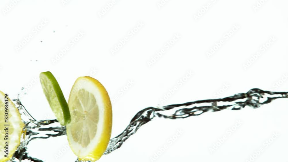 Super slow motion of lime and lemon slices with water splash on white background. Filmed on high speed cinema camera, 1000 fps.