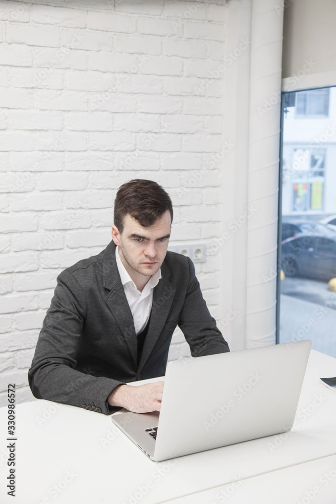 young businessman works in an office with a laptop young businessman works in an office with a laptop