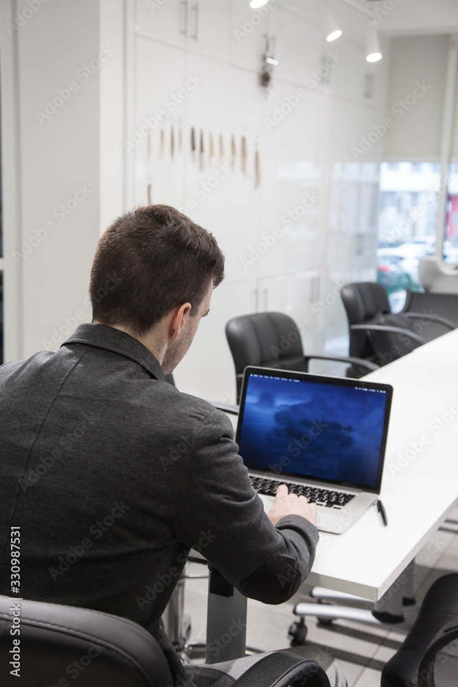 young businessman works in an office with a laptop young businessman works in an office with a laptop