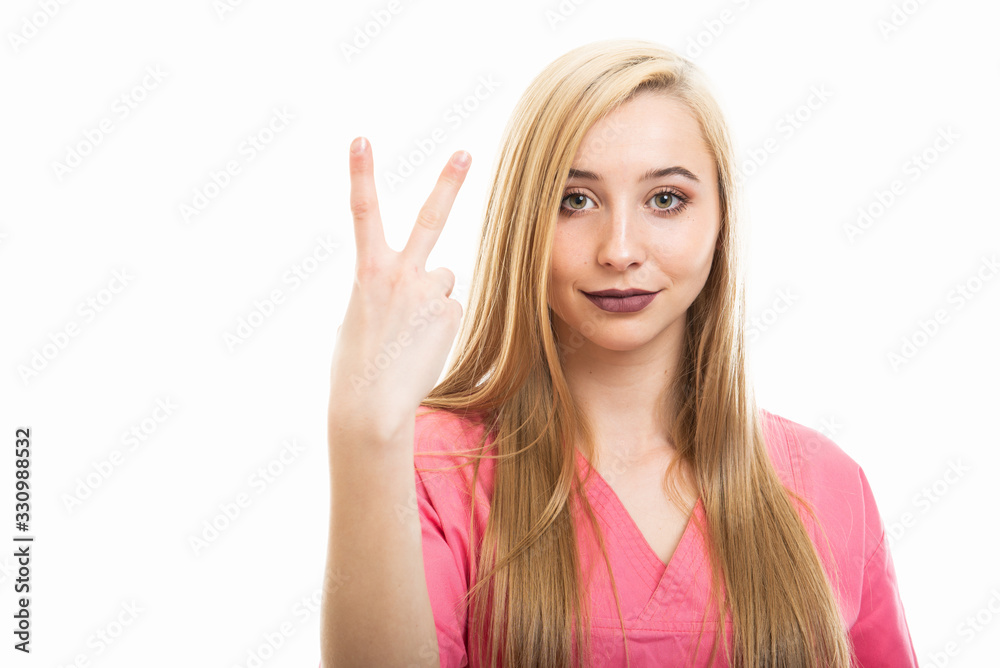 Portrait of young female nurse wearing scrubs showing number two Portrait of young female nurse wearing scrubs showing number two