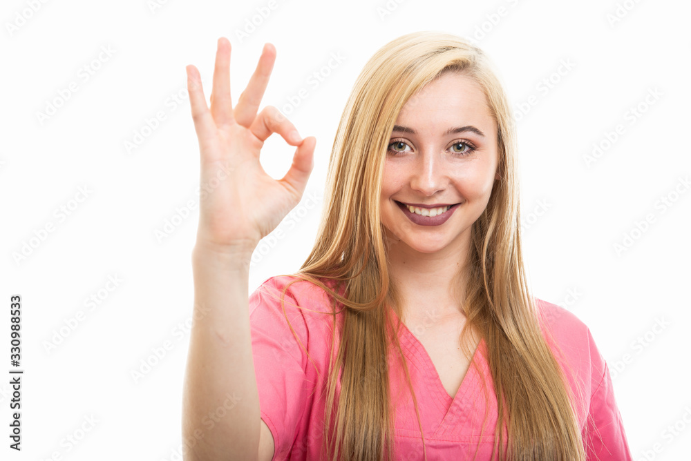 Portrait of young female nurse wearing scrubs showing ok gesture Portrait of young female nurse wearing scrubs showing ok gesture