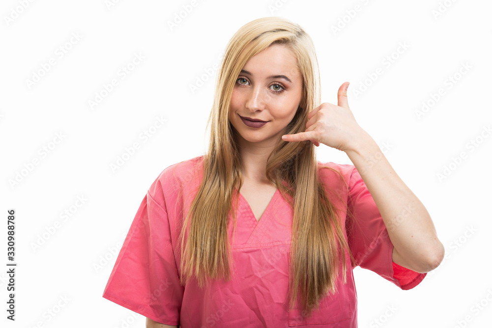 Portrait of female nurse wearing scrubs making calling gesture Portrait of female nurse wearing scrubs making calling gesture