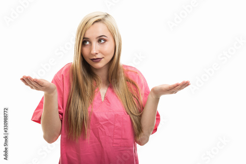 Portrait of female nurse wearing scrubs making not knowing gesture