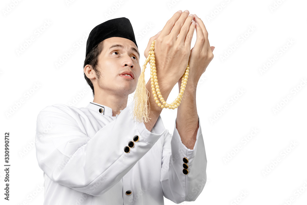 Asian Muslim man praying with prayer beads on his hands Asian Muslim man praying with prayer beads on his hands