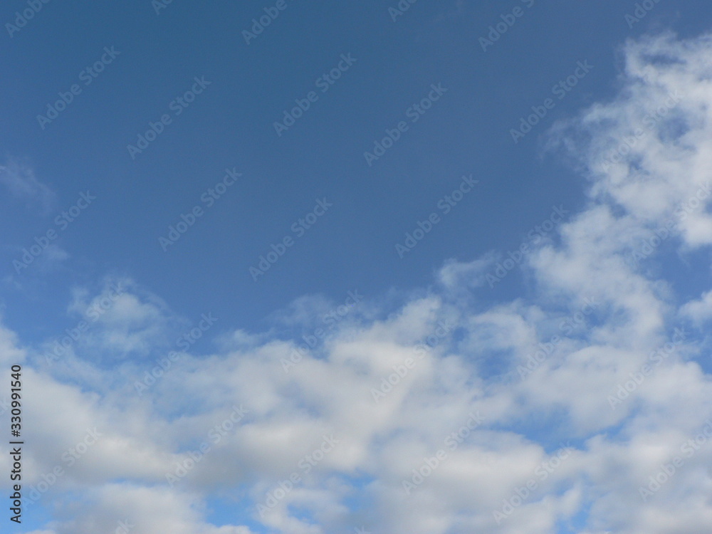 Beautiful blue sky with clouds background. Sky clouds. Air and fluffy clouds in the blue sky on a sunny day, background texture. Copy space for your text.