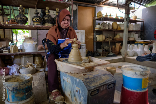 Local woman demonstrates on making traditional clay jar called 
