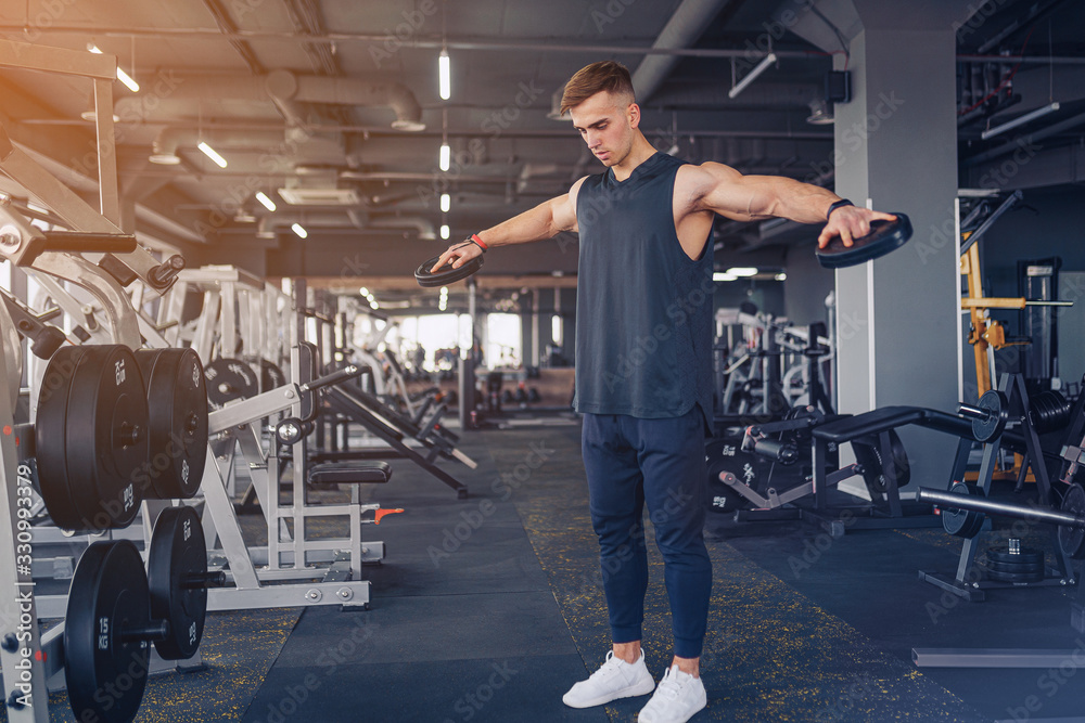 Young Man Preforming Dumbbell Lateral Raise - Exercise For Shoulders. Young Man Preforming Dumbbell Lateral Raise - Exercise For Shoulders.
