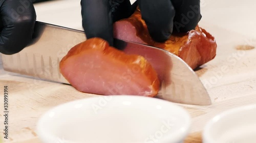 Closeup of slicing a piece of carbonate with a large metal knife.