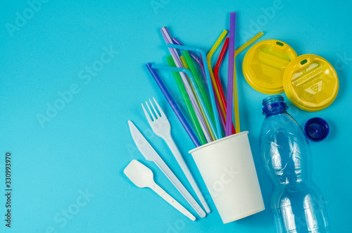 white single use plastic and plastic drink straws on a blue background say no to single use