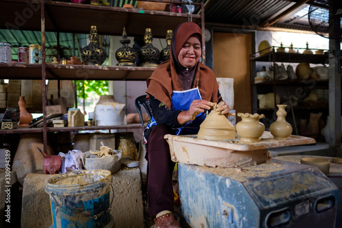 Local woman demonstrates on making traditional clay jar called "Labu Sayong" or Essence Jar of Sayong in Kuala Kangsar, Perak, Malaysia.