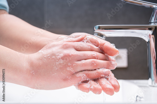 Washing hands with soap in the bathroom