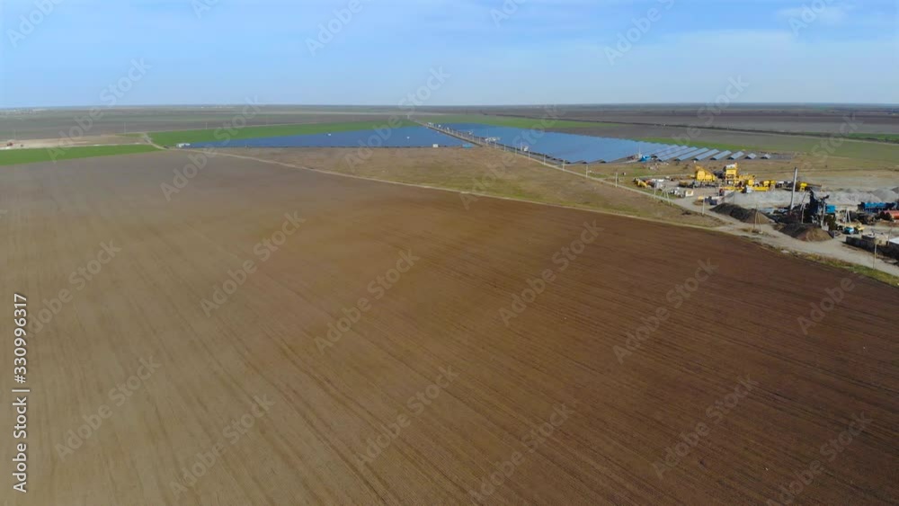 Aerial top view of huge power plant and solar panel between agricultural fields. Alternative environmental energy sources Aerial top view of huge power plant and solar panel between agricultural fields. Alternative environmental energy sources