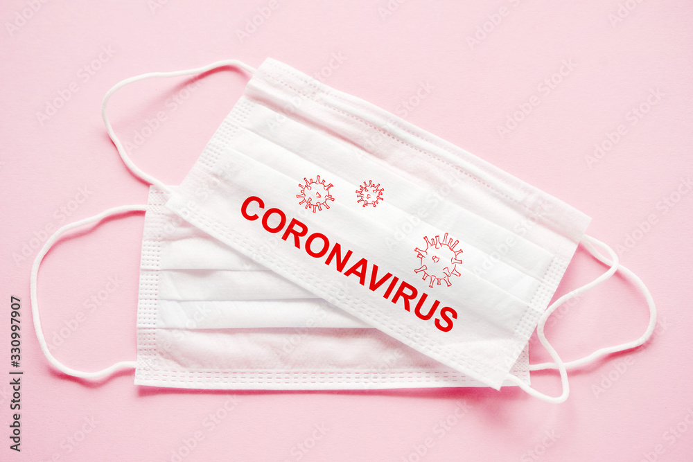 Face mask with the inscription CORONAVIRUS on a pink background, top view. Protection against coronovirus infection. Corona virus concept. Face mask with the inscription CORONAVIRUS on a pink background, top view. Protection against coronovirus infection. Corona virus concept.
