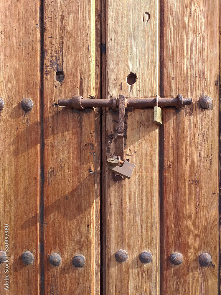 Old wooden background with old iron latch and various padlocks. Tropical construction. Martinique. French West Indies Old wooden background with old iron latch and various padlocks. Tropical construction. Martinique. French West Indies