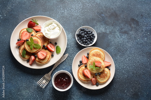 Sweet pancakes served with fresh blueberries   mint  strawberries organic agave syrup. Healthy breakfast concept
