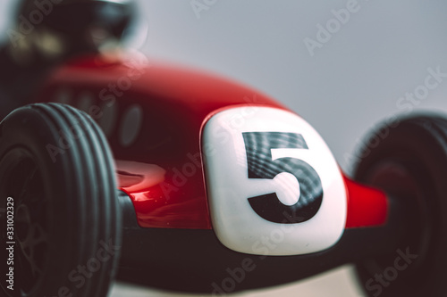 Number five painted on a white plate on a red vintage toy racing car photo