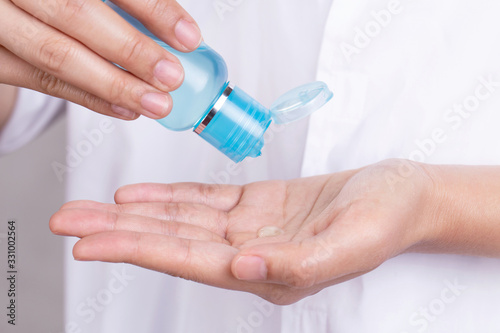 Close Up Hand applying alcohol gel to make cleaning and clear germ  bacteria.bottle with antibacterial antiseptic gel in hand.Coronavirus concept