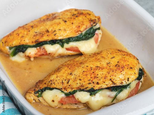 Baked chicken fillet stuffed with spinach, tomatoes and cheese