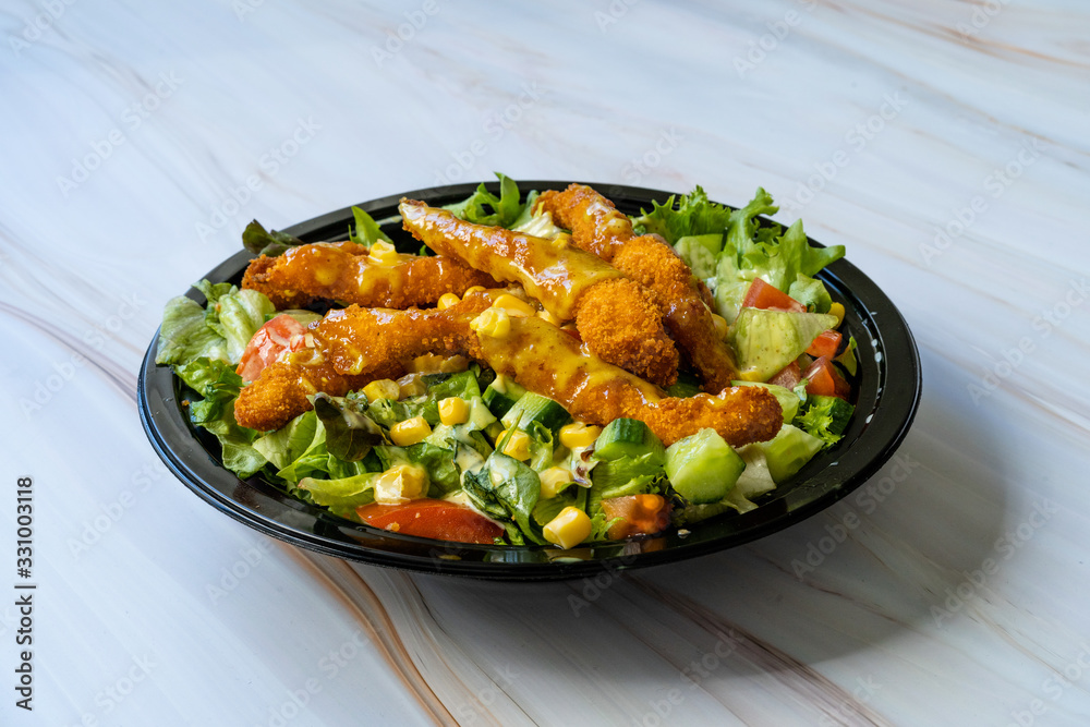Φωτογραφία Take Away Healthy Cajun Salad with Chicken Fingers and Mustard Sauce in Black Plastic Plate Box / Package