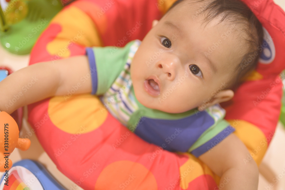 Obraz premium Portrait of a happy asian 4 months baby playing with toys,baby jumper