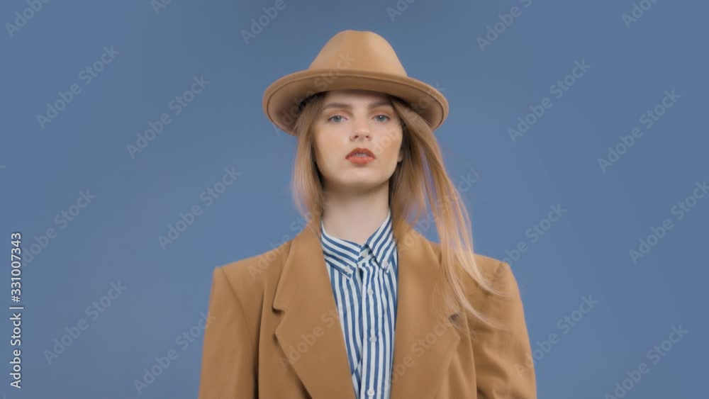 Fashion editorial portrait of blonde model with hair blowing in slow motion from 60 fps