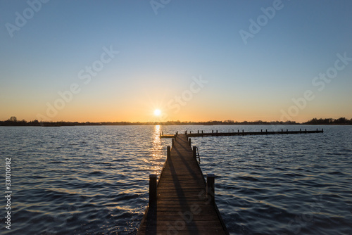 Pier at sunset over Lake Elfhoeven  part of lake area Reeuwijkse Plassen near Gouda  Netherlands